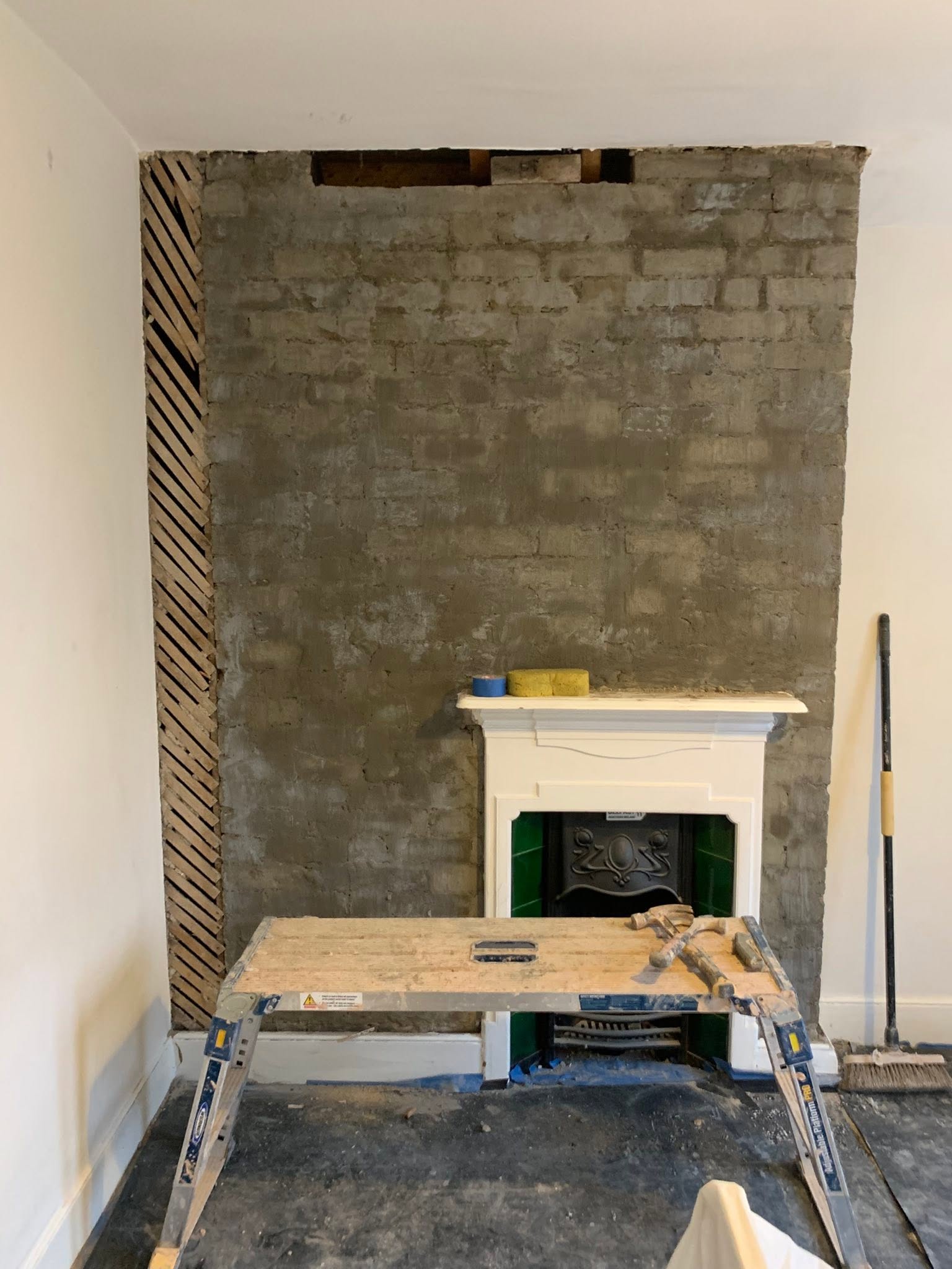 Chimney breast prepared with scratch coat before plastering, period fire surround