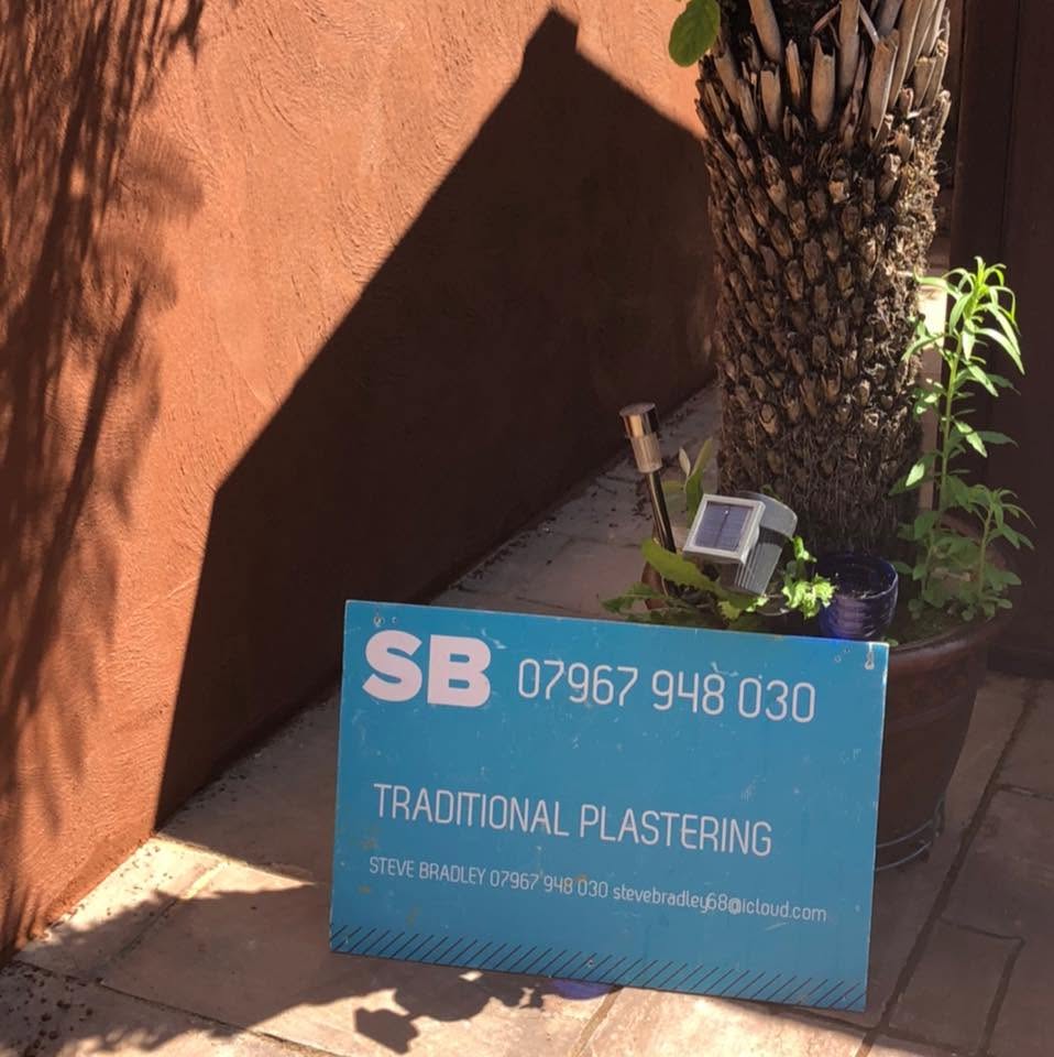Traditional Plastering site board beside a freshly rendered terracotta wall